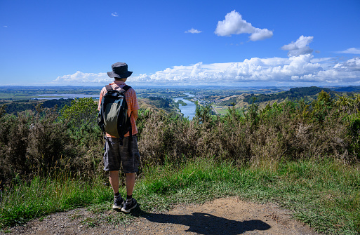 Hiking Hakarimata Summit Track. Man enjoying the views of Huntly and Waikato river. Huntly. New Zealand.