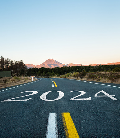 New Year 2024. Text 2024 written on the road to Mt Ngauruhoe. Tongariro National Park. North Island. Vertical format.