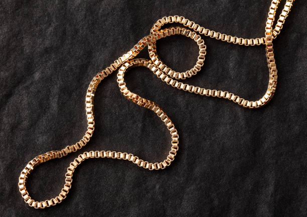 istock Gold chain on black silk fabric. Close-up 1946979260