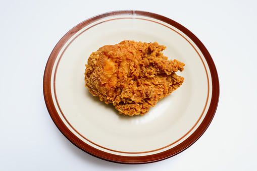 fried chicken on a plate, isolated over white background
