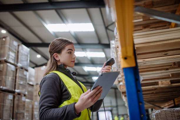 istock Female warehouse worker holding scanner, scanning the barcodes on products in warehouse. Warehouse manager using warehouse scanning system. 1947041573