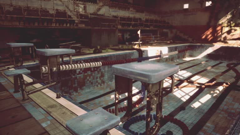 An abandoned swimming pool with empty benches and tables