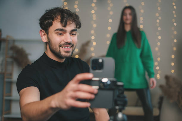 istock Couple dancing during making dance video challenge on smartphone at home. Video blogging. Creative girl and guy of generation Z creating and sharing content for social networks 1947044772