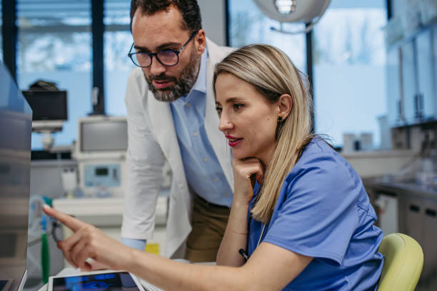 istock Pharmaceutical sales representative presenting new product to doctors in holding tablet. Presenting new pharmaceutical product, drugs, medication. 1947046915