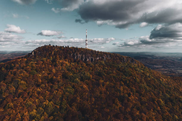 istock Aerial view of transmitter, cell tower surrounded by a forest and clouds, mist. 1947063331