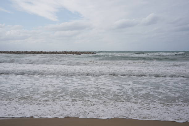istock Strong currents and waves in the sea. Waves successfully crash into the stone breakwater. 1947120534