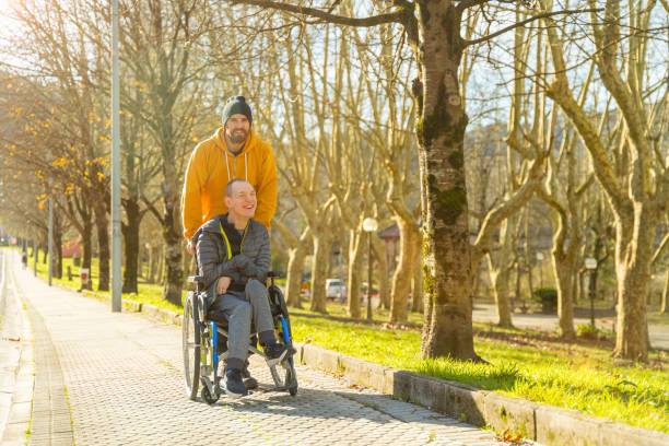 istock Disabled man and friend along a path in a park 1947153230