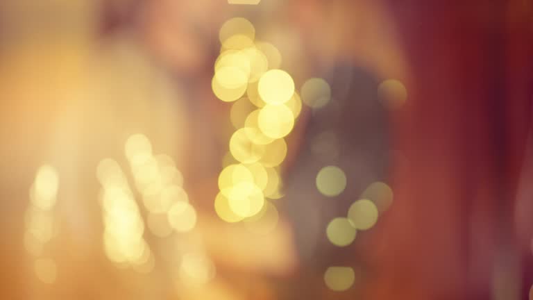 Happy couple dancing at New Year's Eve party.    Abstract image of silver sequins on a dress.