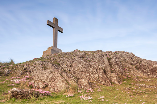 View of Christian Cross on Ynys Llanddwyn Island in Angelsey, against a blue sky
