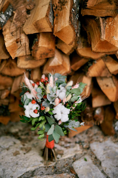 istock Bright wedding bouquet stands on a tile near a stack of firewood 1947169760
