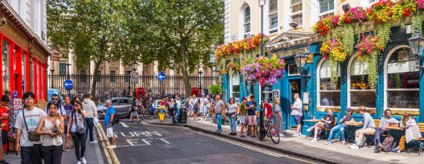 London crowded streets Bloomsbury traditional pub with flower baskets panorama stock photo