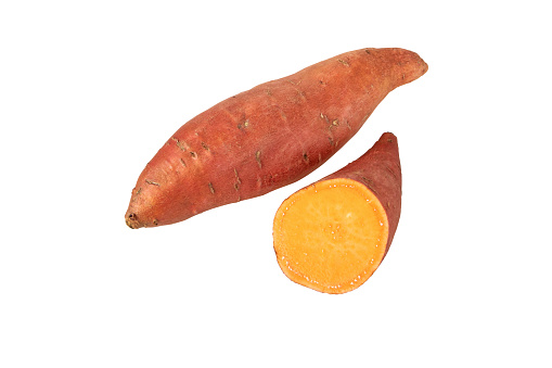 Sweet potato or sweetpotato whole and half tubes with red skin and yellow flesh isolated on white. Vegetable food staple.