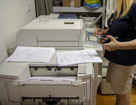Full length of businesswoman using photocopier