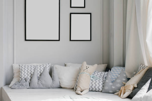 istock Creative pillows in the children's room on the catwalk and frames with empty space, mockups on the wall in the house 1947194997