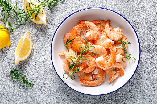 Shrimps with rosemary and lemon on a plate. Healthy food, seafood. Top view