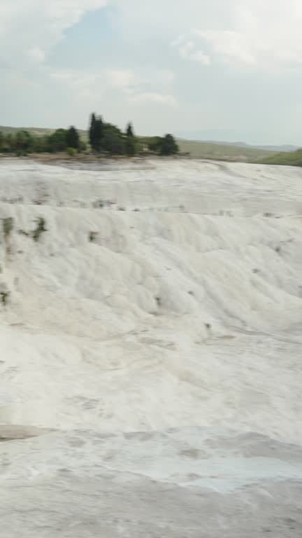 Vertical video. I am walking on the top of the White Mountain, Travertines in Pamukkale, and I am taking a panorama from the top.