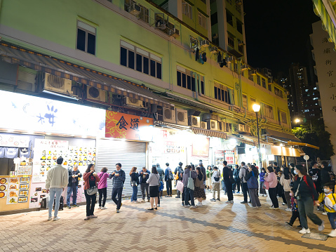 Hong Kong, China - January 13 2024: People walking and buying food and drink at the night market in Tsuen Wan, Hong Kong.