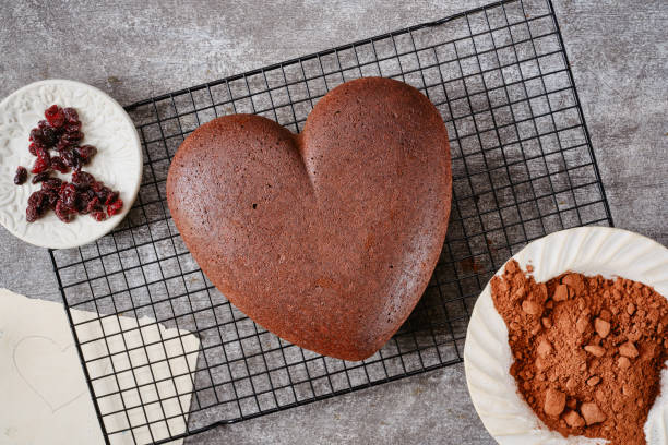 торт в форме сердца на решетке для выпечки на фоне серого камня. - chocolate cake dessert bundt cake стоковые фото и изображения