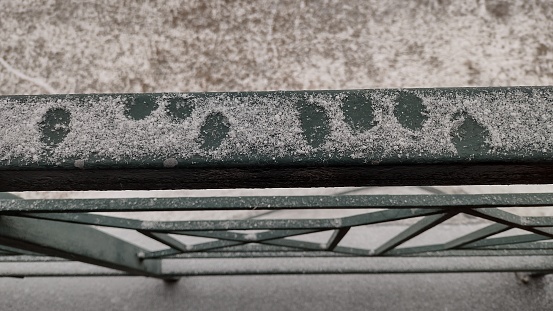 Looking down at 8 fingerprints on in snow covered railing