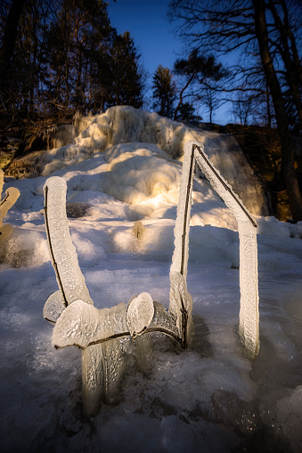 Winter wonderland and icy surrounding framed by sculpture of ice created by effects of wind and water from a nearby waterfall