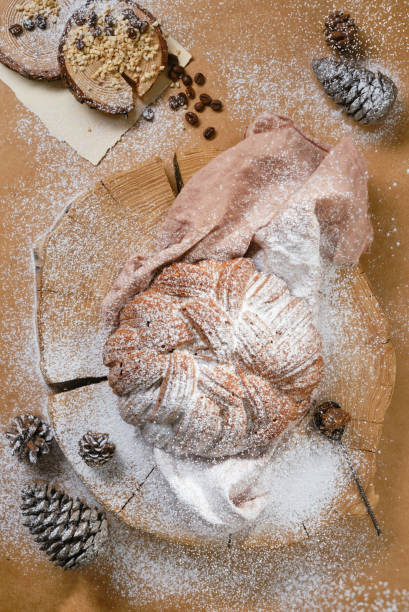 tarta de celebración decorada con azúcar glas con conos y granos de café sobre una tabla de madera. tamizar azúcar en polvo en un pastel de navidad. - pound cake fruitcake cake loaf of bread fotografías e imágenes de stock