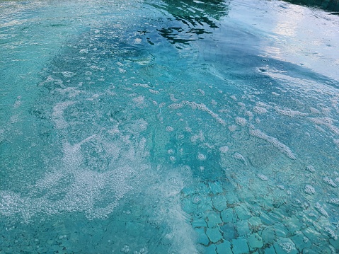 Bubbles on the water surface of a hot tub, outside the house, full frame