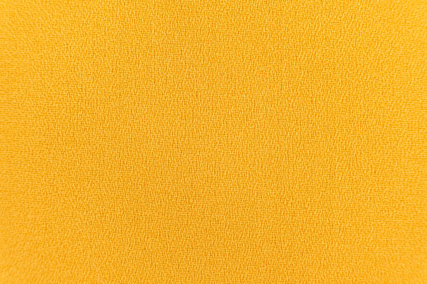 istock Polyester synthetic fabric top view, macro fiber yellow fabric 1947468094