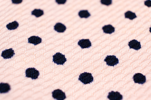 Blue circles patterns on synthetic pink polyester fabric close-up