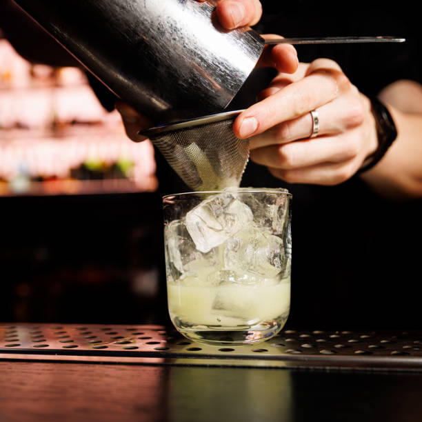 istock Bartender pours a mixed cocktail into a glass with ice. 1947470626