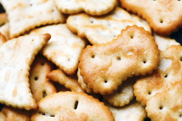 istock Saltine crackers on a plate. Crunchy party snack. Various shapes crackers background. 1947474597