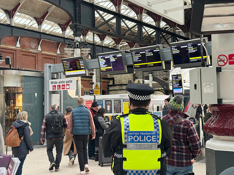 Police office watching passengers at Norwich train station. January 2023