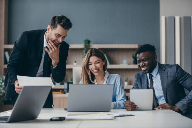 istock Three happy business people using technologies while having meeting in the office together 1947498251