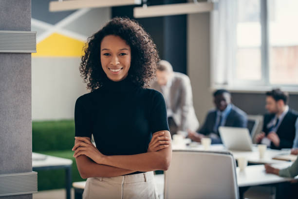 istock Confident African businesswoman smiling at camera while her colleagues working on background 1947500495