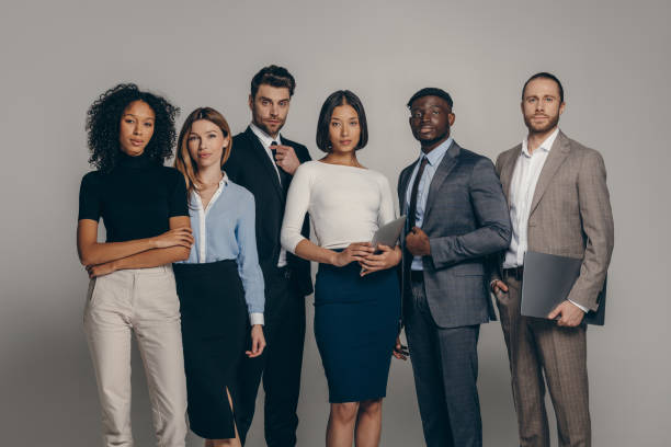 istock Confident young business people looking at camera while standing on beige background together 1947507586