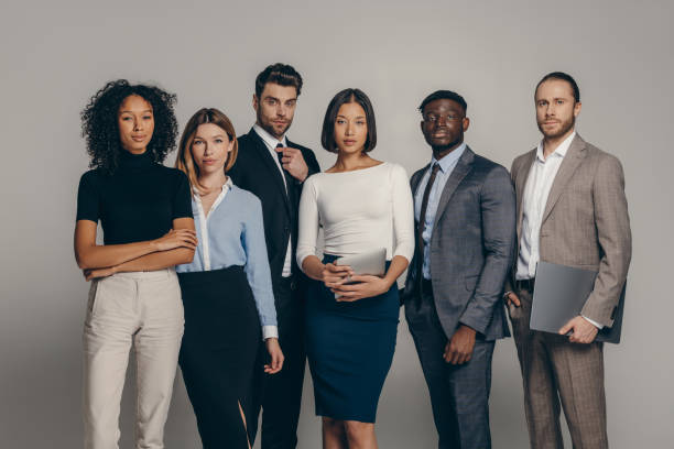 istock Confident young business team looking at camera while standing on beige background together 1947507588