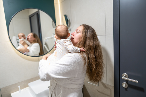 Mother with her baby doing morning routine in bathroom