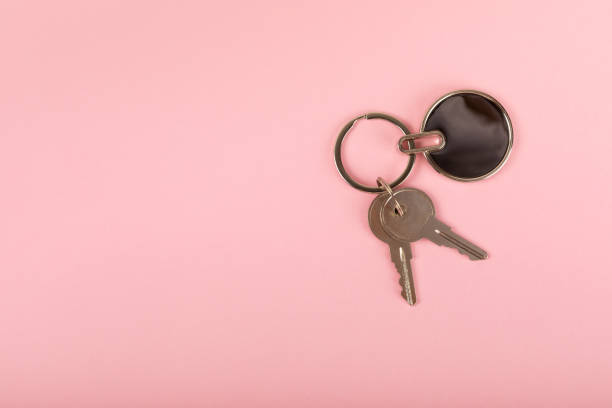 istock Keychain with key ring isolated on a colored background. Concepts for real estate and moving home or renting property. Buying a property. Mock-up keychain.Copy space. 1947519054