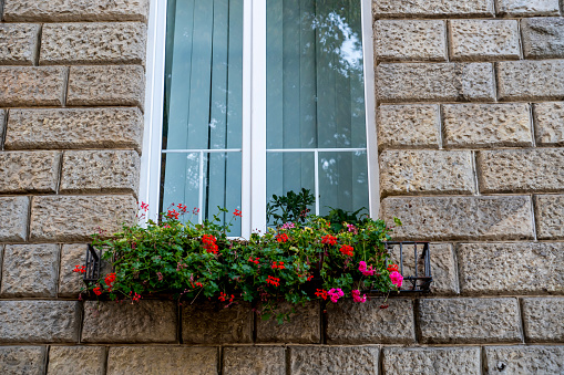 Facade of an old building. Windows with flowers.