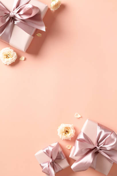 istock Valentines Day vertical background with gift boxes, roses buds on pastel beige background. Love, romance concept. 1947521508