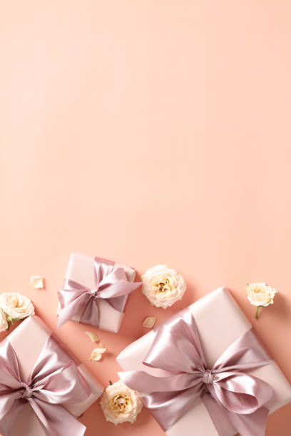 istock Valentine's day vertical banner or poster template. Flat lay gift boxes with ribbon bow, roses buds on pastel beige background. 1947521528