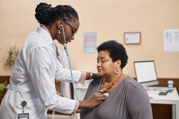 istock Female Health Practitioner with Patient Using Stethoscope 1947527537