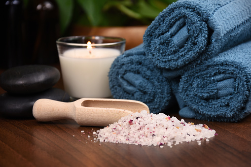 Spa and wellness setting with towels, candle and bath salt photo. Beauty spa treatment composition photo