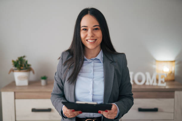 istock Attractive businesswoman standing and holding a folder of documents 1947540287