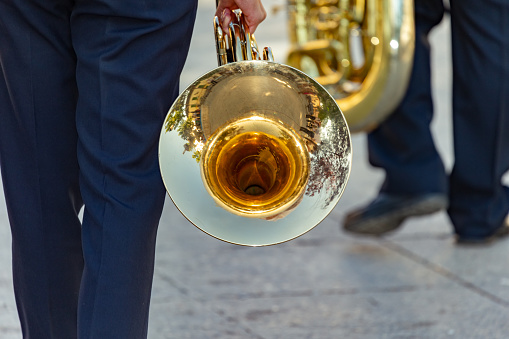 Castilla La Mancha, Spain. Members of the local music band walking through the streets of a Manchegan town carrying a tuba and a French horn.