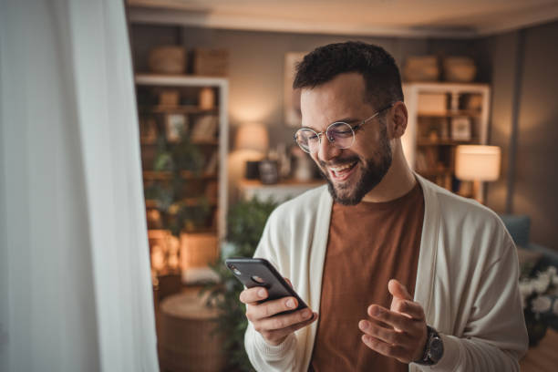 istock Portrait of cheerful man using smartphone at home, daily routine 1947564905