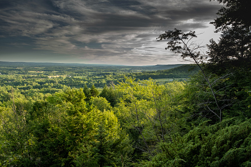 Viewpoint of a green valley and turbulent clouds approaching.