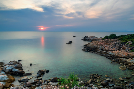 Aerial seascape at sunset of natural stone arch and turquoise sea in Ko Man Klang, Rayong, Thailand. Famous travel destination and summer holiday vacation in tropical country, Siam.