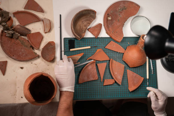 istock Archeologist clean old pottery dish working late night in office. Copy space 1947648055