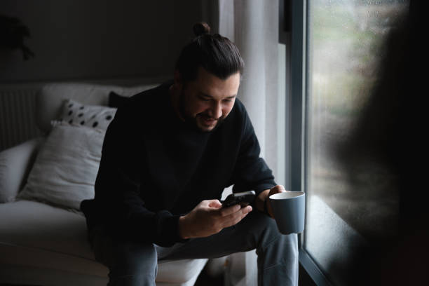 istock Young Man looking at smart phone 1947657200