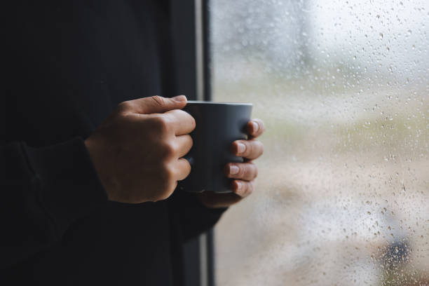 istock Man holding coffee cup while looking away at home 1947659822